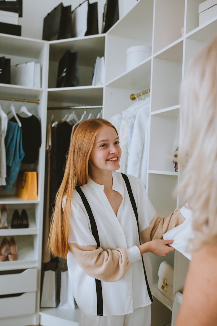 A young woman with long hair shops for clothes in a stylish boutique closet setting.